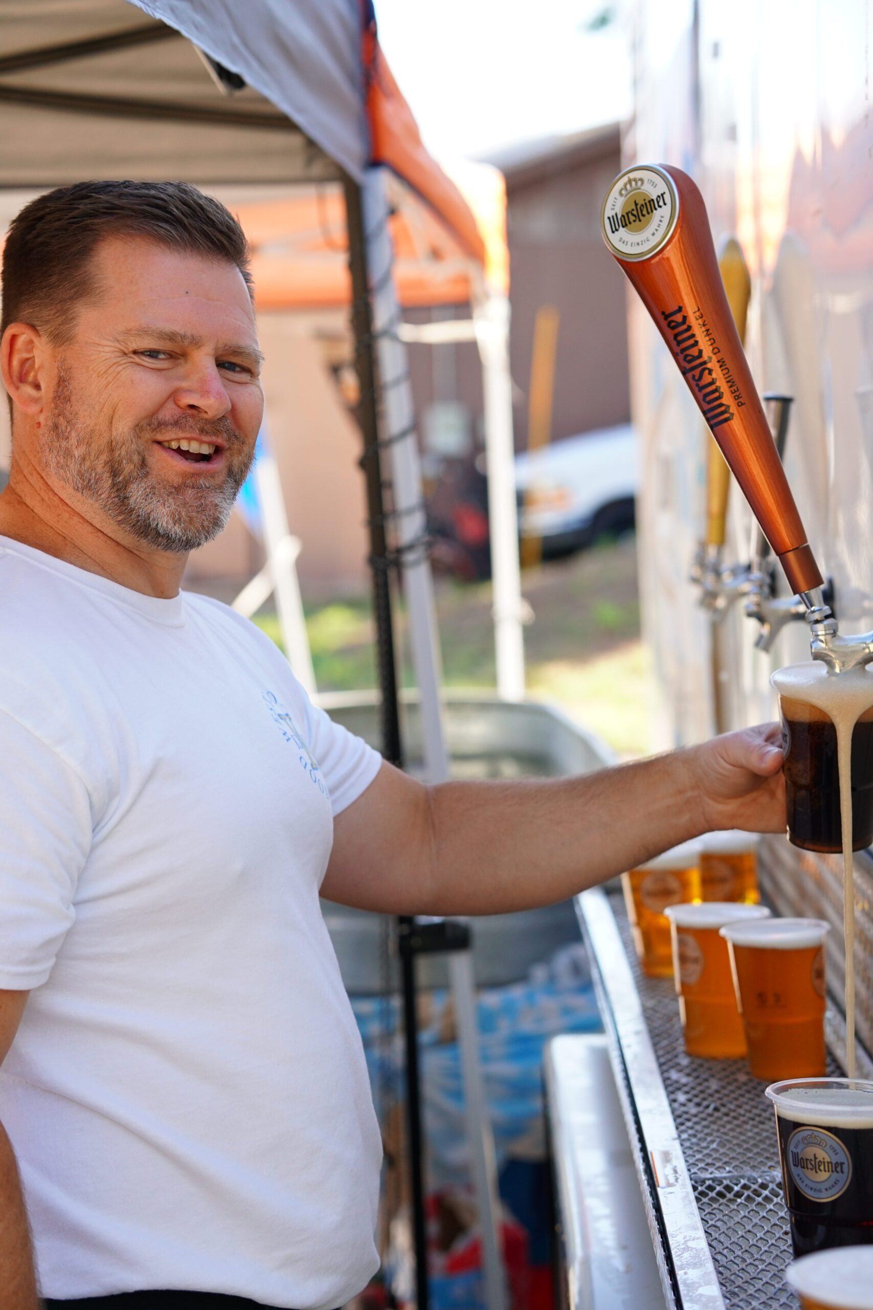 An Oktoberfest volunteer pours beer at the beverage station