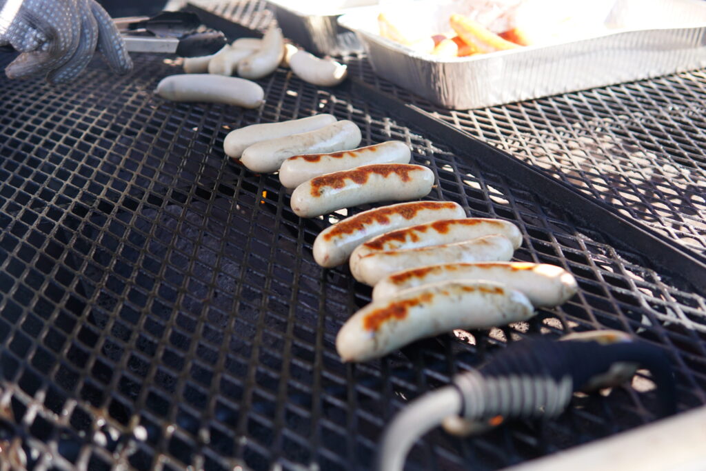 Freshly cooked bratwurst sizzles on the grill