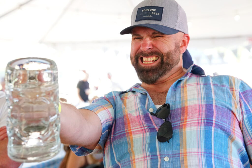 A stein hoisting competitor grimmaces