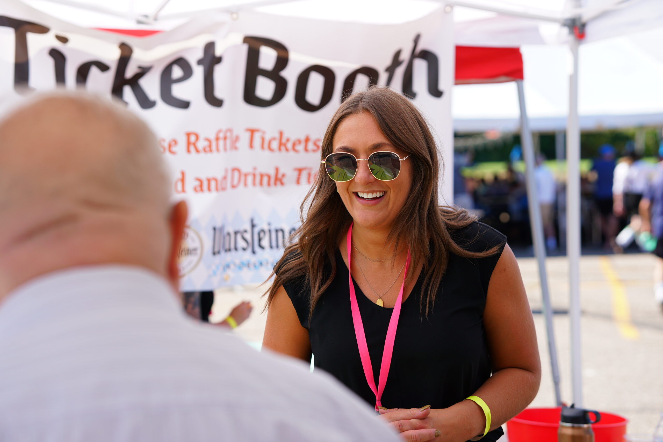 An Oktoberfest volunteer welcomes a guest at the ticket booth