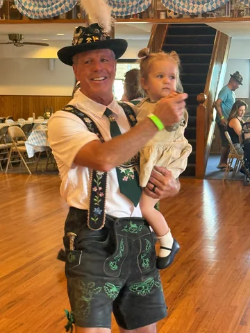 A guest in traditional clothing holding a young child