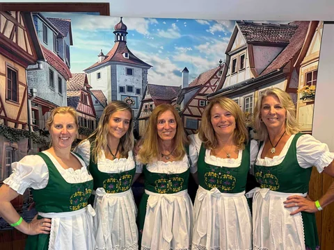 A group in matching traditional dresses at the photo backdrop
