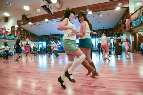 Two guests dancing in Alpine hats