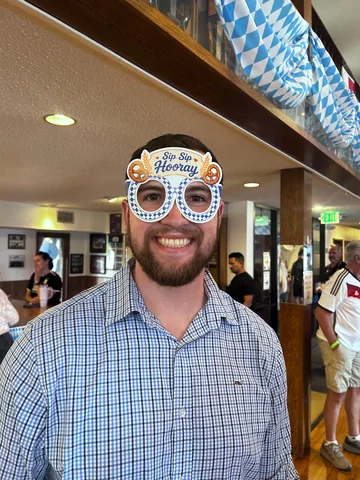 A guest wearing festive Oktoberfest glasses