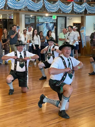 Schuhplattler performers moving across the dance floor