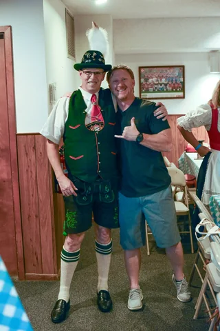 Two guests smiling together by the clubhouse doorway