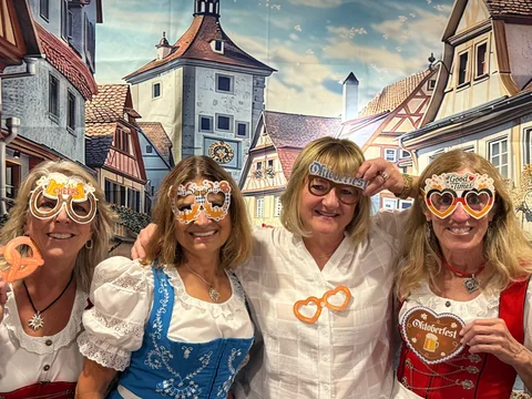 Friends smiling together with Oktoberfest props