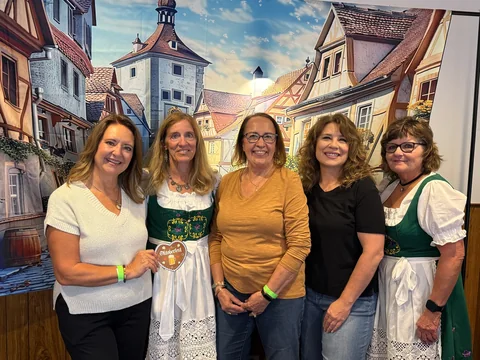 Five friends smiling at the photo backdrop