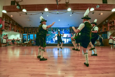 Schuhplattler dancers leaping during a performance