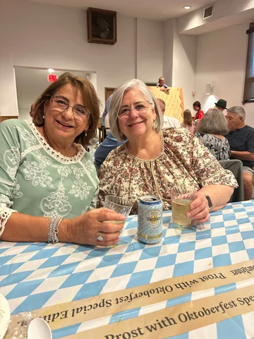 Two guests smiling at a blue-and-white covered table