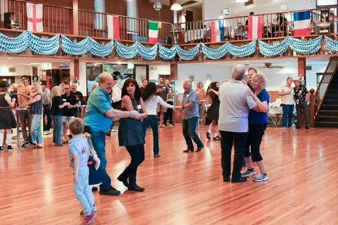 Guests dancing together beneath the clubhouse balcony
